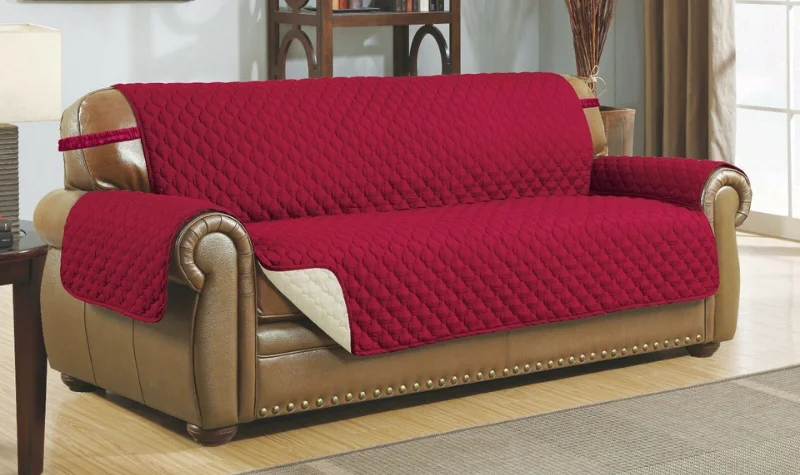 Red quilted sofa cover placed on a classic leather sofa in Dubai